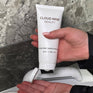 A model squeezing CLOUD NINE skin preparation gel into her hand with the Rejuvenate Beauty Device in the background.
