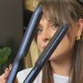 Woman with brown long hair styling waves with The Contouring Wide Iron 
